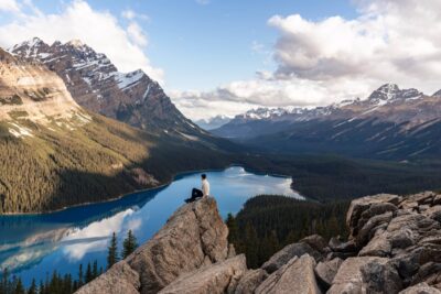 Peyto Lake Photoshoot. Photo of a guy sat on top of a rock looking out over Peyto lake.