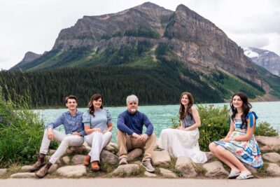 Lake Louise family photoshoot. Sitting on rocks by the water. Vermillion Lakes family photography. Lauren Hollamby Photography