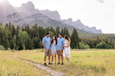 Quarry Lake Canmore Family Photoshoot. Taken by Lauren Hollamby Photography. Family in a field with mountain backdrop at golden hour.