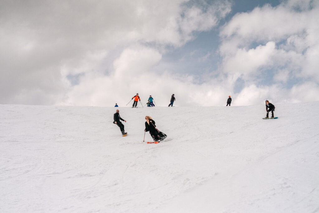Wedding party skiing down Wawa bowl. Banff Sunshine Village. Ski elopement wedding. Lauren Hollamby Photography.